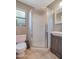 Bathroom featuring a glass-enclosed shower, a vanity, and a toilet near a window at 2656 N 84Th Pl, Scottsdale, AZ 85257