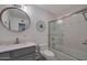 Updated bathroom with a round mirror, modern fixtures, and a shower over tub at 2656 N 84Th Pl, Scottsdale, AZ 85257