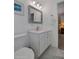 Bright bathroom featuring a single sink vanity with a silver-framed mirror and marble-look tile flooring at 2656 N 84Th Pl, Scottsdale, AZ 85257