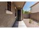 Exterior entryway featuring a secure metal door and desert landscaping in a sunny neighborhood at 3349 E Merlot St, Gilbert, AZ 85298