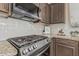 Close up of a modern gas cooktop in a kitchen with granite countertops and tiled backsplash at 3349 E Merlot St, Gilbert, AZ 85298