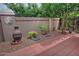 Charming backyard with decorative wall art, lush plants, and a brick-paved area for relaxing at 3510 E Hampton Ave # 74, Mesa, AZ 85204