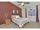 Comfortable bedroom with a ceiling fan, warm red accent wall, and natural light at 3510 E Hampton Ave # 74, Mesa, AZ 85204
