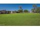 Vast front yard showcasing a well-maintained lawn, outbuildings, and ample space for recreation or potential development at 3738 E Hash Knife Draw Rd, Queen Creek, AZ 85140