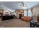 Open-concept living room featuring multiple seating areas, neutral carpet, and a fireplace at 3738 E Hash Knife Draw Rd, Queen Creek, AZ 85140