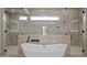 Elegant bathroom featuring a freestanding tub, dual walk-in showers, and travertine walls at 39302 N 30Th Dr, Phoenix, AZ 85086