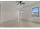 Spacious bedroom with wood-style floors, a ceiling fan, and two windows, providing plenty of natural light at 39302 N 30Th Dr, Phoenix, AZ 85086
