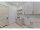 Functional laundry room featuring gray cabinets, a sink, and modern appliances at 39302 N 30Th Dr, Phoenix, AZ 85086