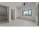A spacious living room with a window, ceiling fan, tile floors, and closet space at 39302 N 30Th Dr, Phoenix, AZ 85086