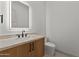 Elegant powder room with wood vanity, a lighted mirror, and modern fixtures at 39302 N 30Th Dr, Phoenix, AZ 85086