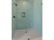 Modern glass shower with blue brick pattern tile and dark hardware fixtures at 39302 N 30Th Dr, Phoenix, AZ 85086