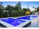 Expansive backyard featuring a luminous pool and spa, complemented by lush greenery and stylish outdoor seating at 4002 N 33Rd Pl, Phoenix, AZ 85018