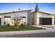 Charming home featuring drought resistant landscaping, a stone accent and a black modern garage door at 4002 N 33Rd Pl, Phoenix, AZ 85018