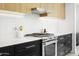 Kitchen features stainless steel oven and range with black and wood cabinets and a white backsplash at 4002 N 33Rd Pl, Phoenix, AZ 85018