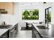 Modern kitchen featuring stainless steel appliances and sink area, next to an eat-in area overlooking the lush backyard at 4002 N 33Rd Pl, Phoenix, AZ 85018