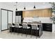 Bright kitchen features a large island with seating, stainless steel appliances, and stylish black and wood cabinetry at 4002 N 33Rd Pl, Phoenix, AZ 85018