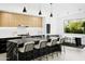 Modern kitchen with an expansive island, sleek bar stools, and an open dining area with outdoor views at 4002 N 33Rd Pl, Phoenix, AZ 85018