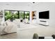 Bright living room with large windows and neutral tones, modern fireplace, and sleek TV at 4002 N 33Rd Pl, Phoenix, AZ 85018