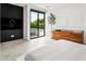 Spacious bedroom with a sleek dresser, modern TV, and sliding glass doors to the outdoors at 4002 N 33Rd Pl, Phoenix, AZ 85018