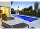 Backyard pool featuring a tanning ledge, surrounded by lush landscaping and lounge chairs for relaxation at 4002 N 33Rd Pl, Phoenix, AZ 85018