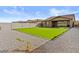 Large backyard with lush grass, a spacious patio, and attractive landscaping at 40990 W Agave Rd, Maricopa, AZ 85138