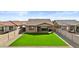 Well maintained backyard with artificial grass and block fence, perfect for relaxing and entertaining at 40990 W Agave Rd, Maricopa, AZ 85138