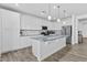 Modern kitchen with white cabinetry, stainless steel appliances, and an island with pendant lighting at 40990 W Agave Rd, Maricopa, AZ 85138