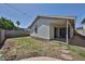 Exterior view of the home showcasing a spacious backyard with a covered patio and block fencing at 4445 W Oraibi Dr, Glendale, AZ 85308