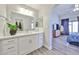 Bright bathroom featuring a large mirror, white countertop with drawers, and a plant for added décor at 4445 W Oraibi Dr, Glendale, AZ 85308