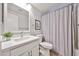 Bright bathroom featuring a modern vanity with white countertops and a bathtub with stylish shower curtain at 4445 W Oraibi Dr, Glendale, AZ 85308