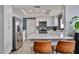 Modern kitchen with stainless steel appliances and a breakfast bar, with stylish wallpaper at 4445 W Oraibi Dr, Glendale, AZ 85308