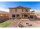 Spacious backyard featuring gravel landscaping, green lawn area, in-ground firepit, and covered patio at 44859 W Sage Brush Dr, Maricopa, AZ 85139