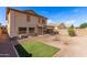 Expansive backyard boasting gravel landscaping, green lawn area, an in-ground firepit, and covered patio at 44859 W Sage Brush Dr, Maricopa, AZ 85139