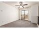 This neutral bedroom features plush carpet, a sliding glass door, and views of the community at 44859 W Sage Brush Dr, Maricopa, AZ 85139