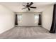 Carpeted primary bedroom with ceiling fan, light walls, and natural light from two windows at 44859 W Sage Brush Dr, Maricopa, AZ 85139