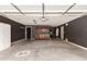 This garage features an automatic door, dark walls, cabinetry, and concrete floors at 44859 W Sage Brush Dr, Maricopa, AZ 85139