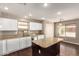 Well-lit kitchen features white cabinets, granite countertops, and a functional center island at 44859 W Sage Brush Dr, Maricopa, AZ 85139