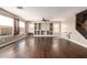 Spacious living room featuring beautiful hardwood floors, custom built-in shelving, and large sunny windows at 44859 W Sage Brush Dr, Maricopa, AZ 85139