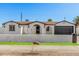 Inviting single-story home features crisp white exterior, contrasting trim, and a well-kept lawn at 4611 N 79Th Dr, Phoenix, AZ 85033