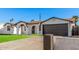 Charming single-story home boasts a manicured lawn, arched entry, and contrasting trim, offering curb appeal at 4611 N 79Th Dr, Phoenix, AZ 85033