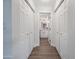 Hallway with multiple closets leading to a bright bathroom vanity with dual sinks at 5025 W New World Dr, Glendale, AZ 85302