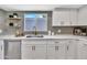 Beautiful kitchen showcasing modern fixtures, including a stainless steel dishwasher, and floating shelves at 5025 W New World Dr, Glendale, AZ 85302