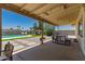 Covered patio with outdoor dining area overlooking the pool and meticulously designed backyard oasis at 5031 W Grandview Rd, Glendale, AZ 85306