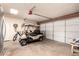 Spacious garage featuring a golf cart, storage shelves, and a dart board for entertainment at 5031 W Grandview Rd, Glendale, AZ 85306