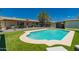 Sparkling pool in a backyard featuring turf, mature shade trees, outdoor seating and green landscaping at 5031 W Grandview Rd, Glendale, AZ 85306