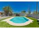 Inviting pool surrounded by artificial turf with mature trees and a privacy fence at 5031 W Grandview Rd, Glendale, AZ 85306