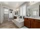 Elegant bathroom with a soaking tub, dual vanities, and shuttered windows for natural light at 6235 S Odessa Dr, Gilbert, AZ 85298