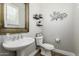 Chic powder room featuring pedestal sink, decorative mirror, floating shelves, and modern fixtures at 6235 S Odessa Dr, Gilbert, AZ 85298