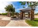 Outdoor picnic area with stone pillars, trellises, seating, and lovely landscaping at 6235 S Odessa Dr, Gilbert, AZ 85298