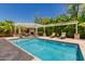 Backyard pool with a pergola, stone pillars, an outdoor fireplace, lounge chairs and lush, mature landscaping at 6235 S Odessa Dr, Gilbert, AZ 85298